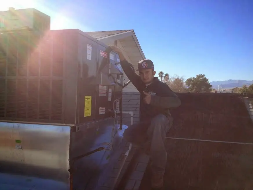 HVAC technician performing AC Tune-Up on a rooftop unit in South Lakes